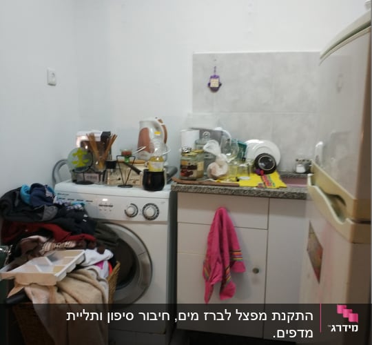 מכונת כביסה עם בגדים וכלים על השיש